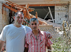 Kiryat Shemona resident in front of rocket-damaged home